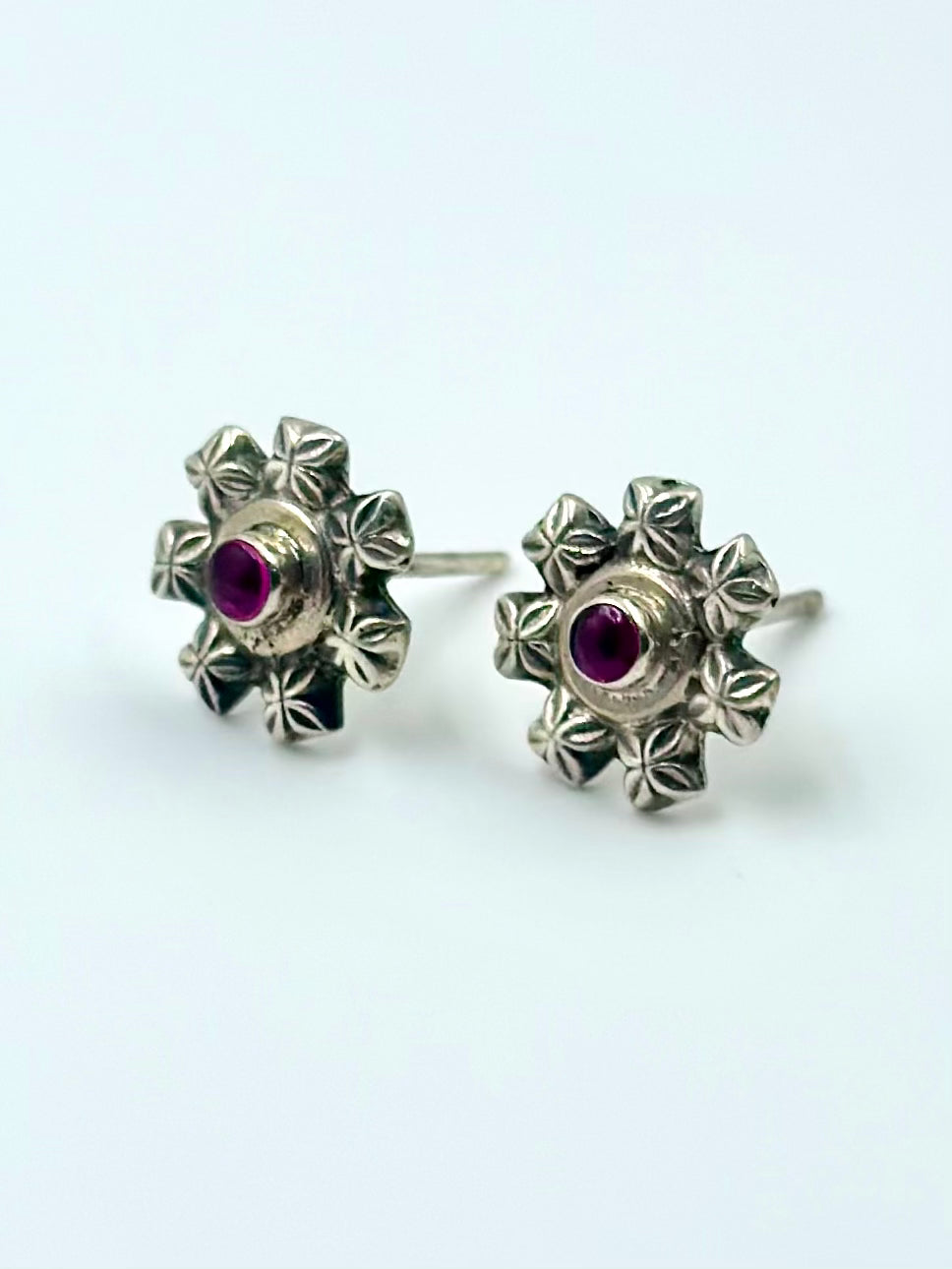Oxidised, flower shaped, studded with ruby, studs in sterling silver