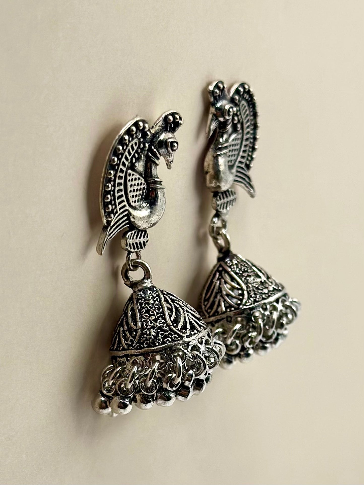 Majestic peacock shaped, oxidised sterling silver jhumkas with lined details