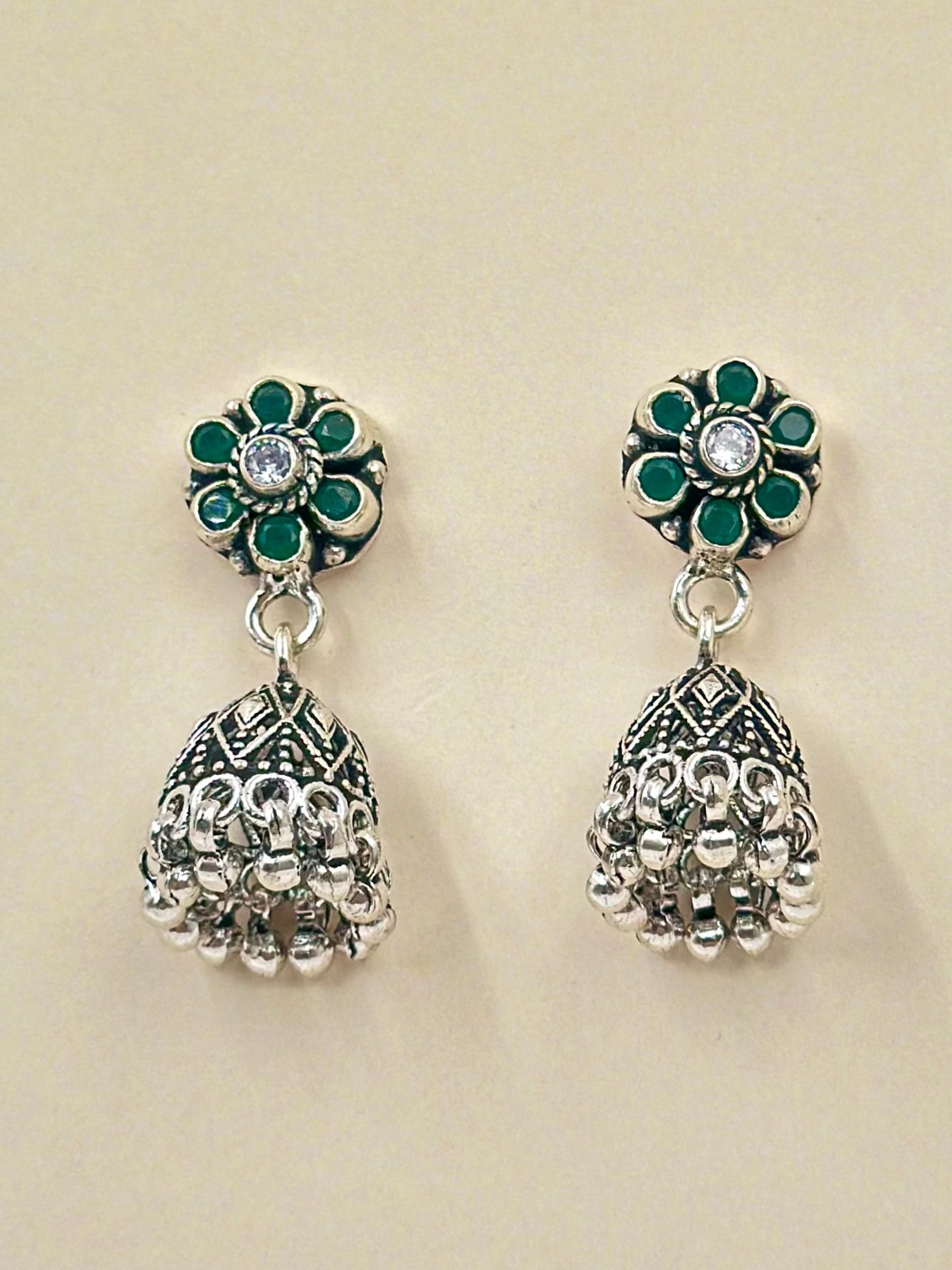 Green stones studded, flower shaped, oxidised sterling silver jhumkas