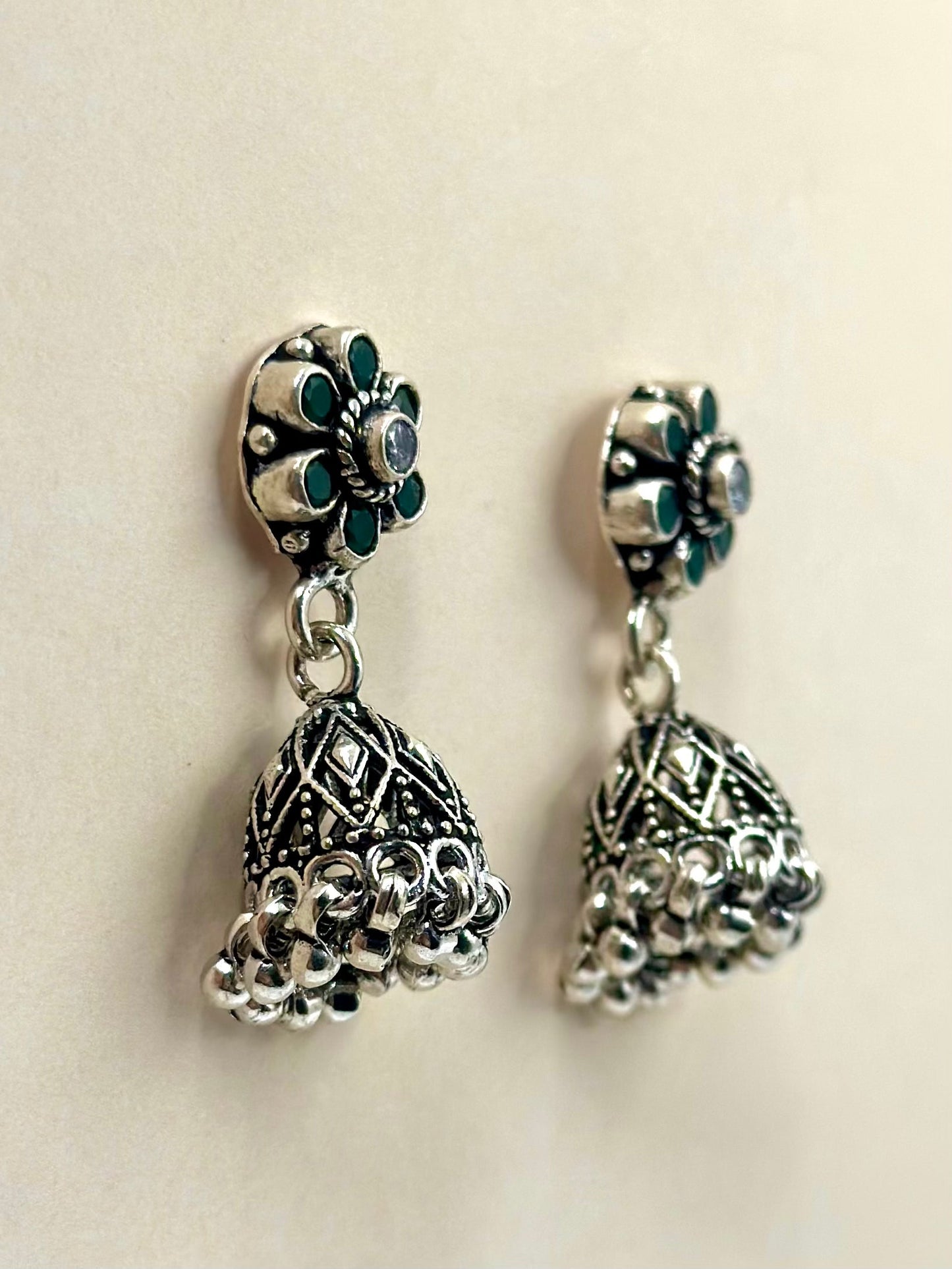 Green stones studded, flower shaped, oxidised sterling silver jhumkas