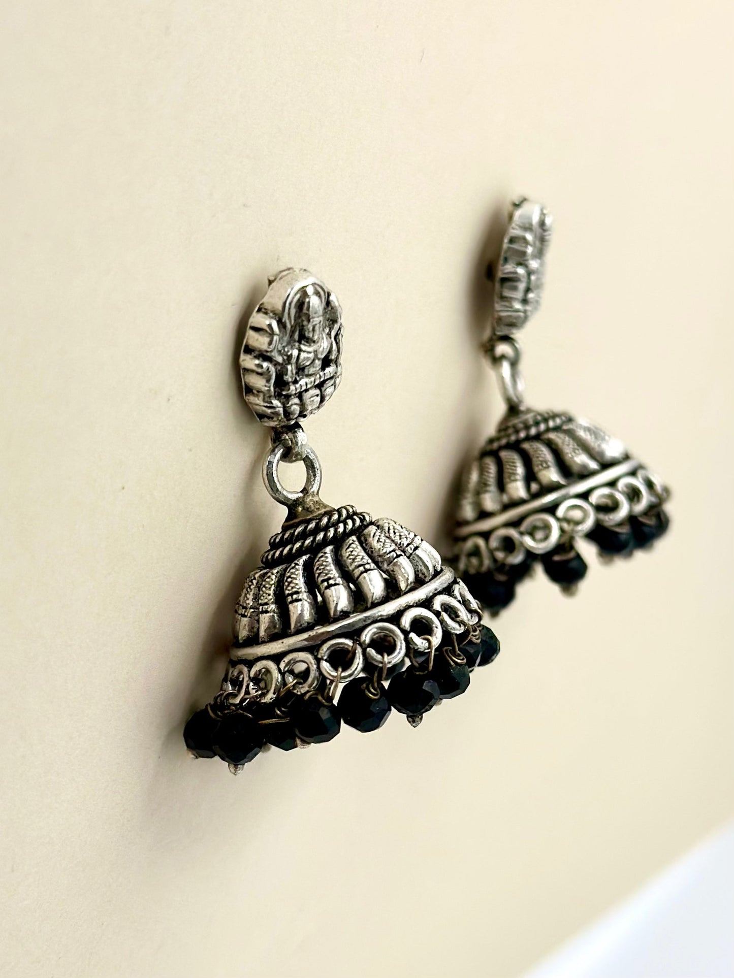 Temple themed, black stones studded oxidised sterling silver jhumkas
