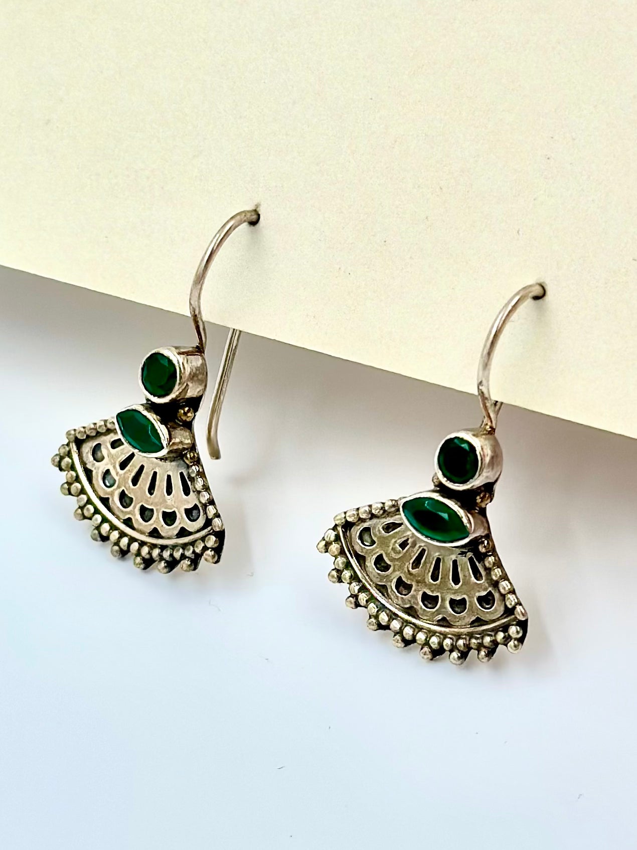 Shaped like a Peacock's veil, studded with emerald stones, oxidised, sterling silver drop earrings