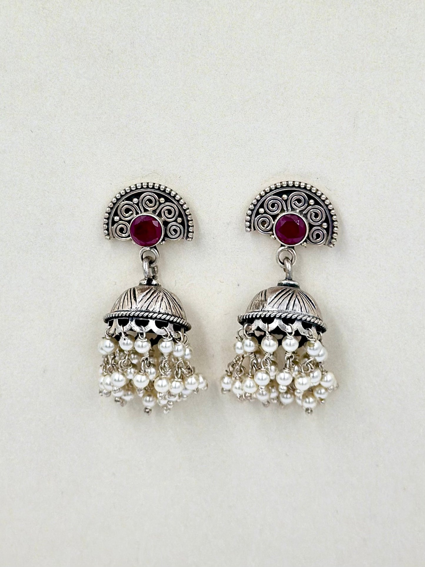Red stones as center piece, oxidised, pearls studded sterling silver jhumkas