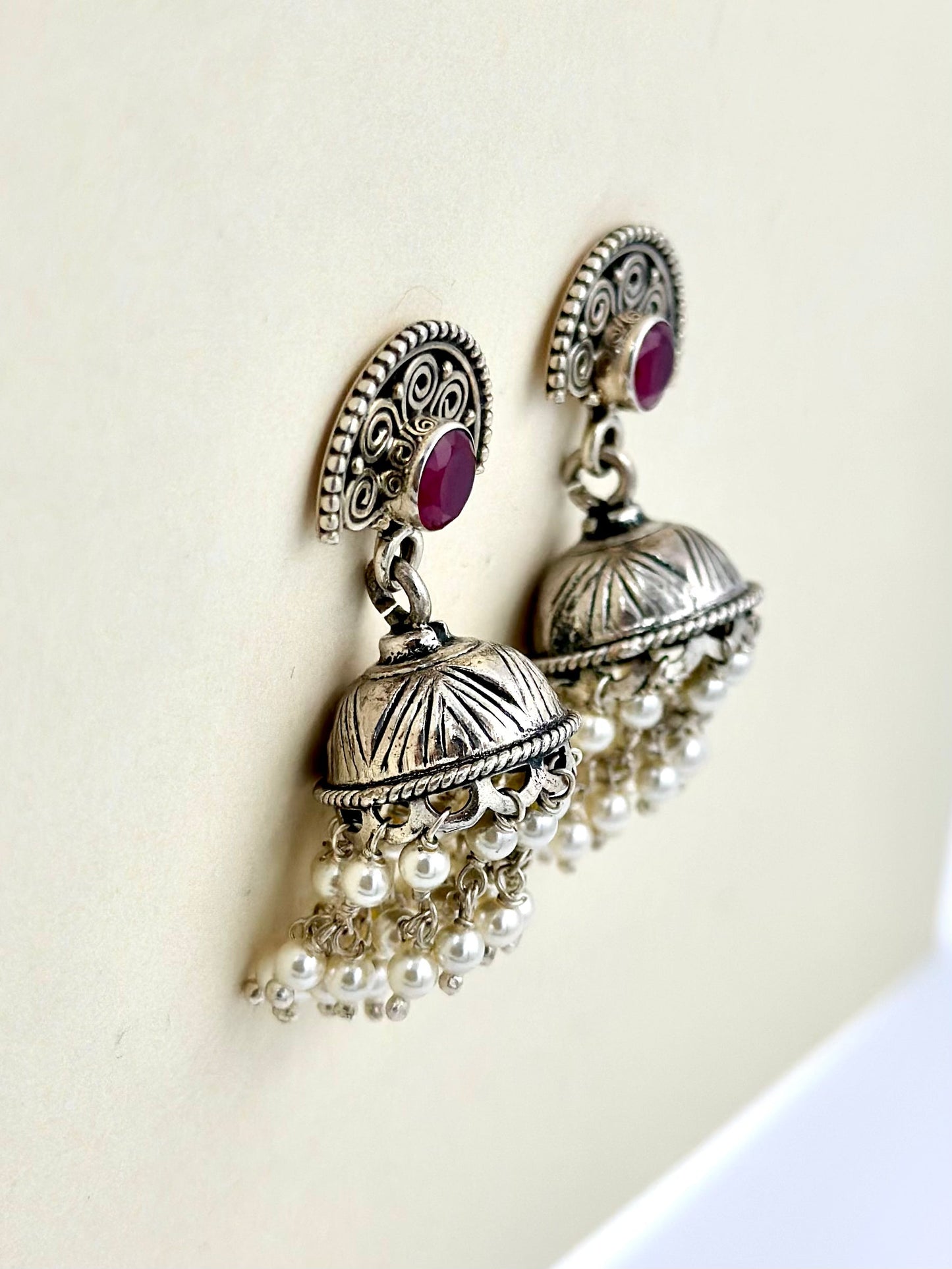 Red stones as center piece, oxidised, pearls studded sterling silver jhumkas