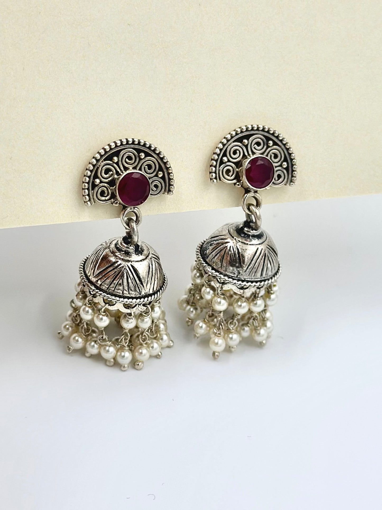 Red stones as center piece, oxidised, pearls studded sterling silver jhumkas
