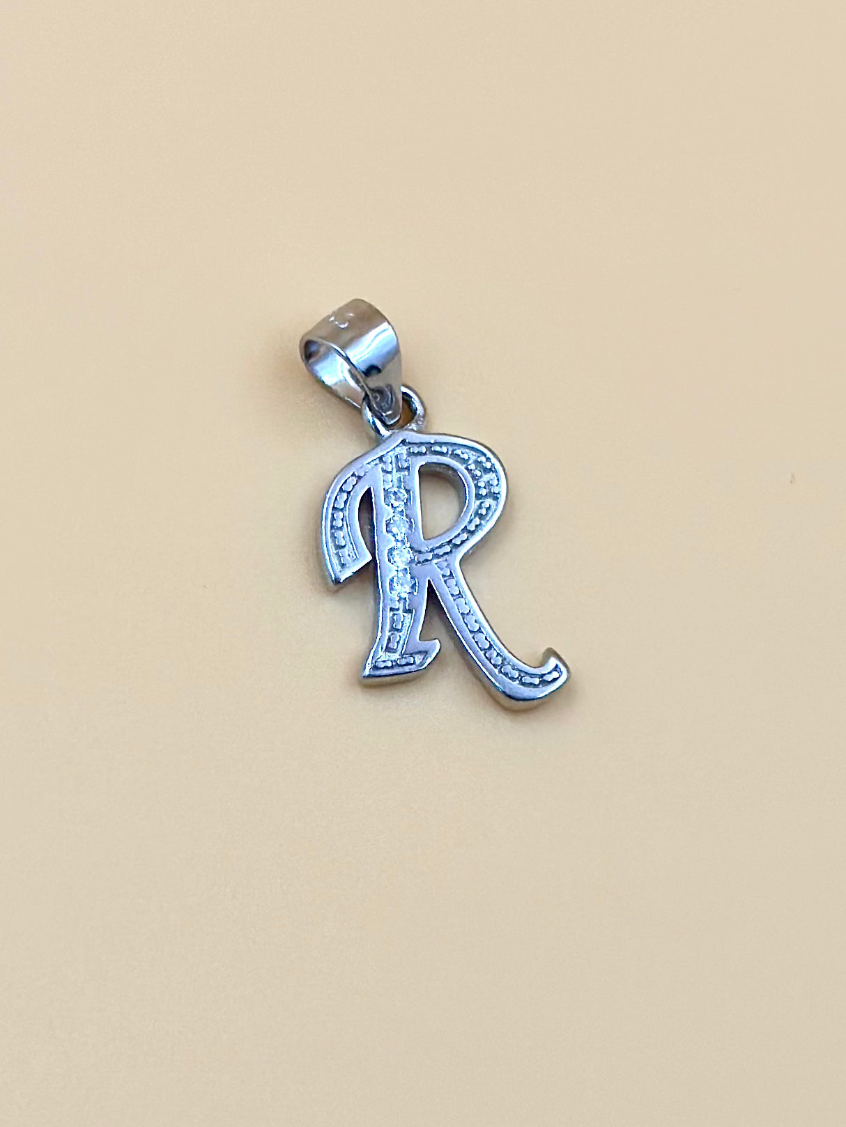 R shaped, zircon studded sterling silver pendant