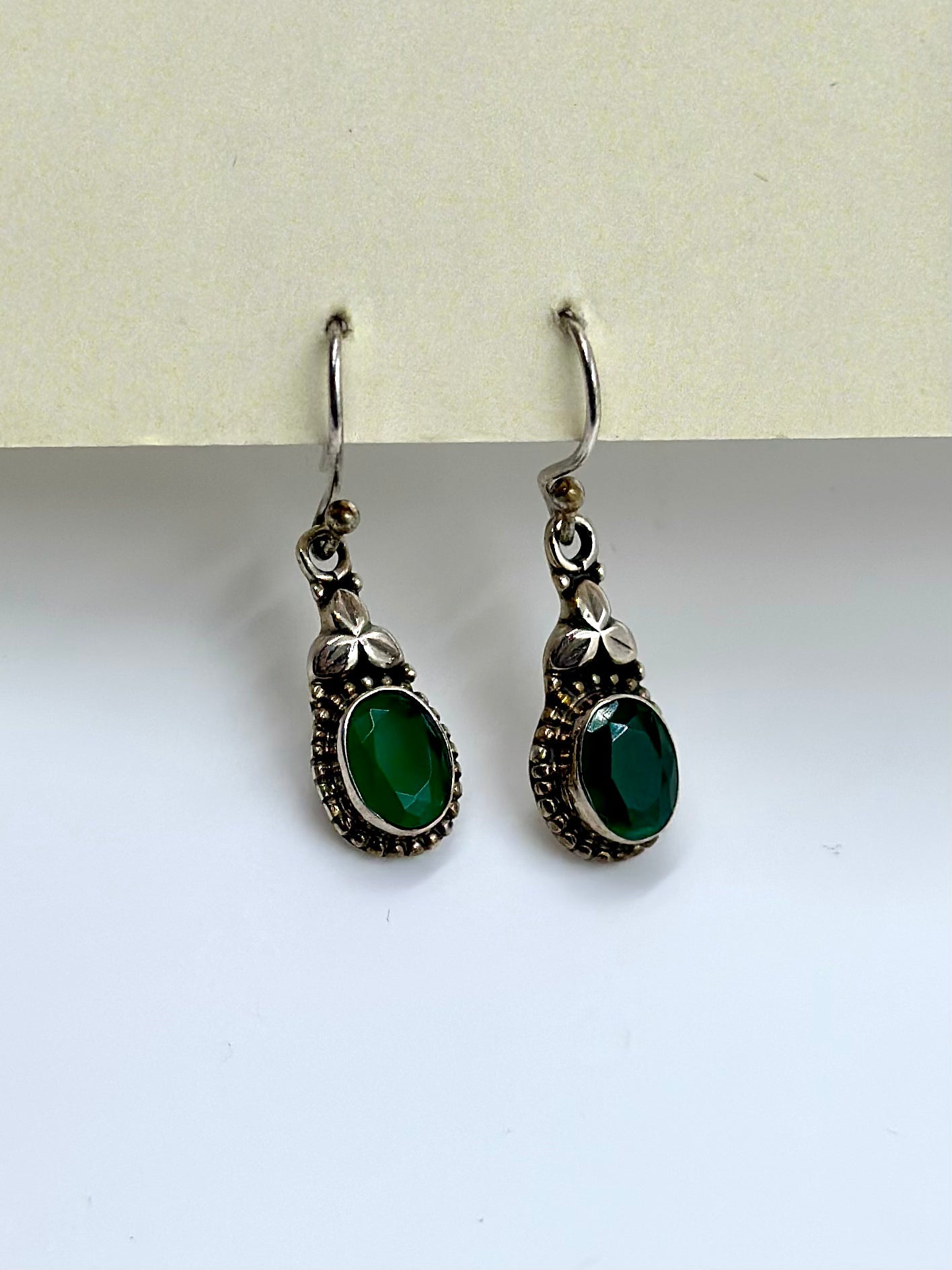 Encrusted with stone and a small oxidised flower, sterling silver drop earrings