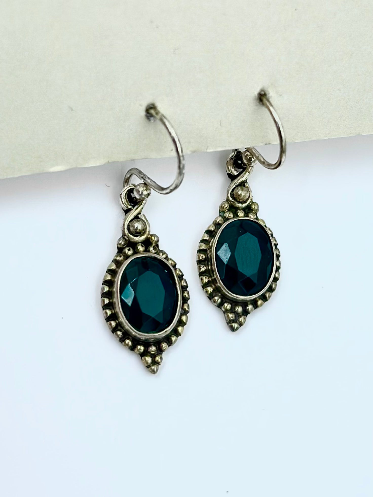 With an emerald centre piece and fine oxidised detailing around, sterling silver drop earrings