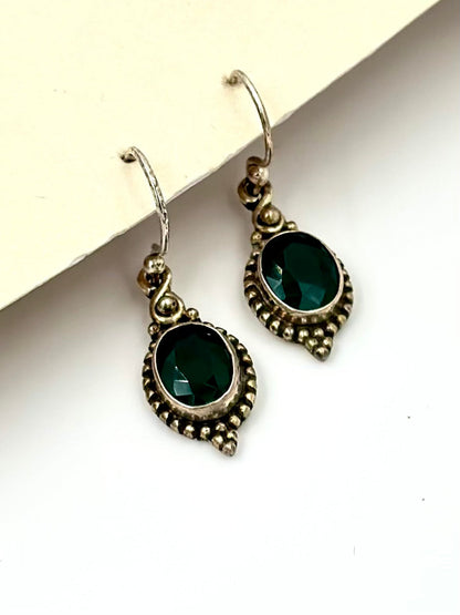 With an emerald centre piece and fine oxidised detailing around, sterling silver drop earrings