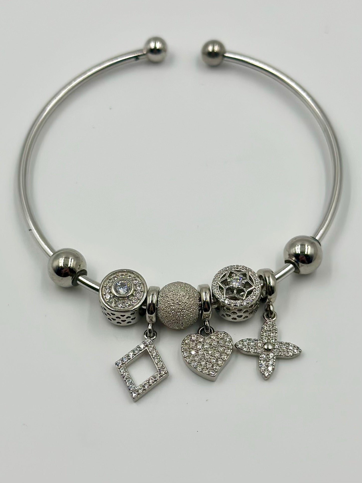 Zircon studded, many shapes sterling silver charm bracelet