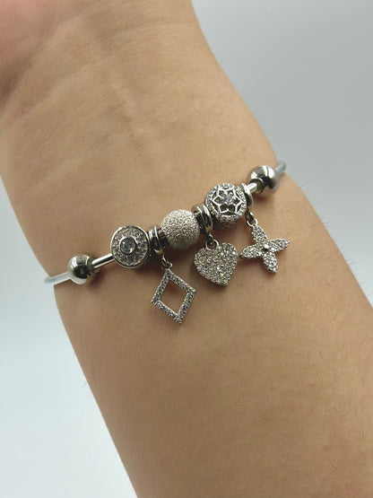 Zircon studded, many shapes sterling silver charm bracelet