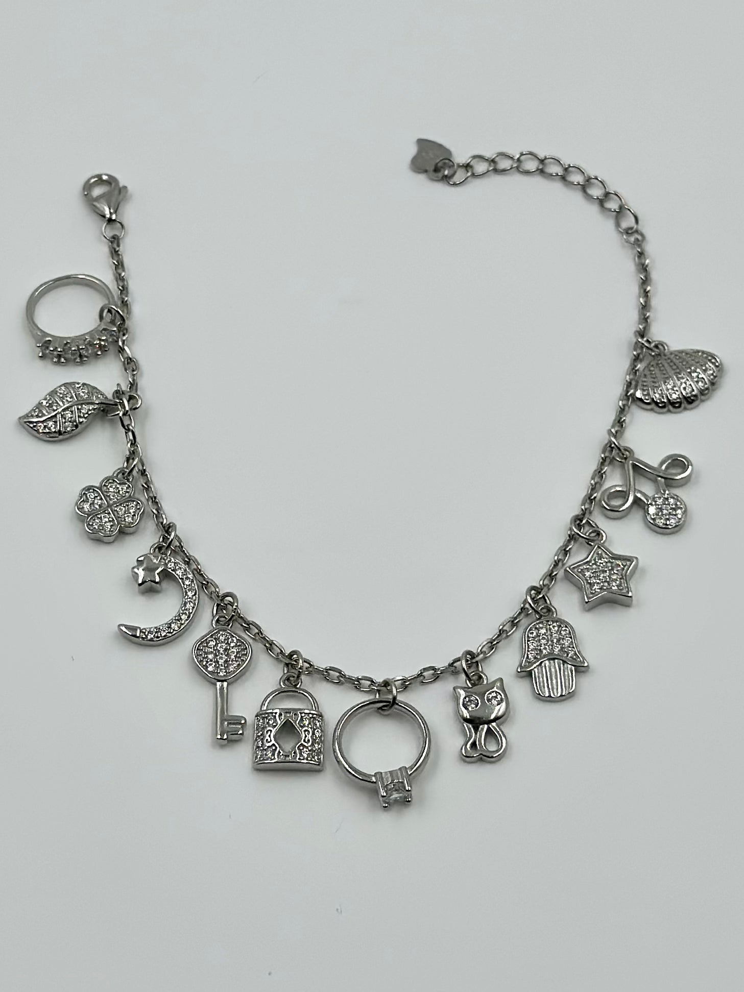 Zircon studded, many shapes charms studded sterling silver charm bracelet