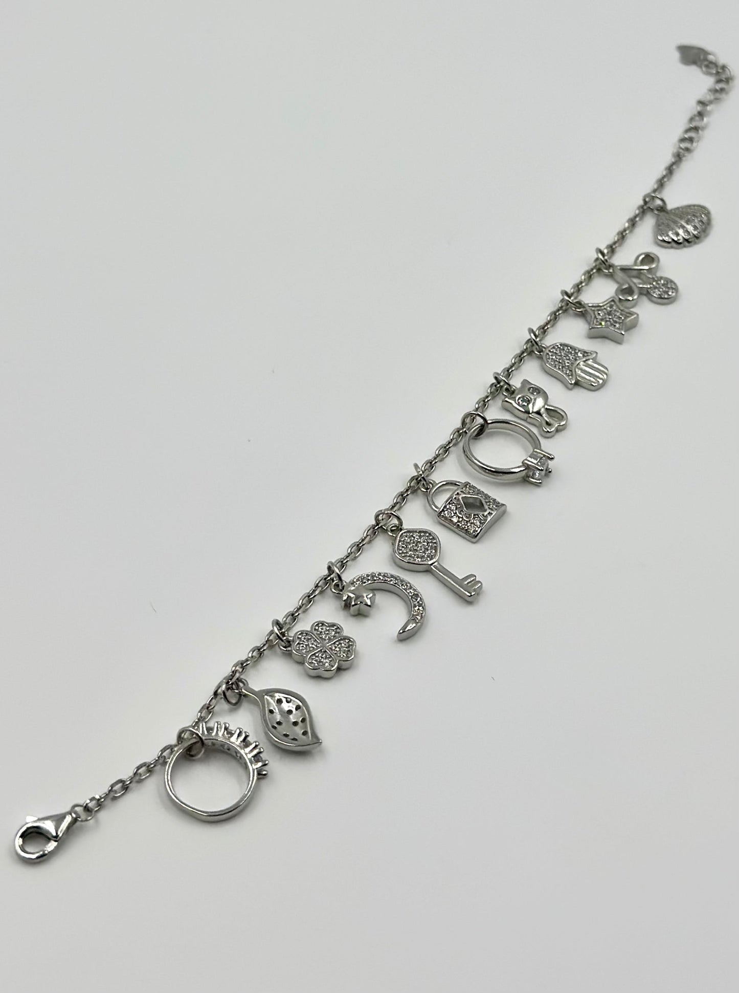 Zircon studded, many shapes charms studded sterling silver charm bracelet