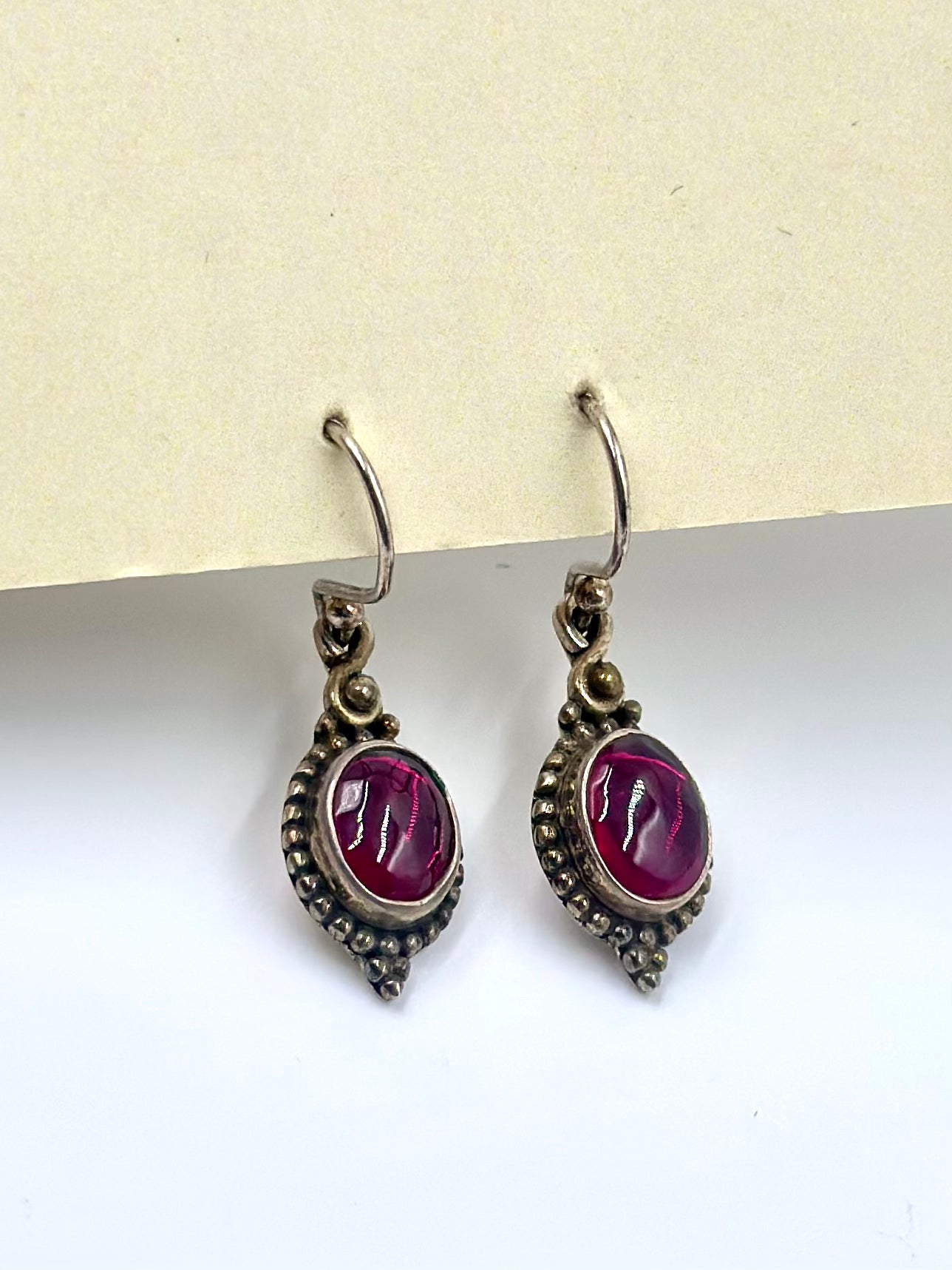 With an emerald centre piece and fine oxidised detailing around, sterling silver drop earrings