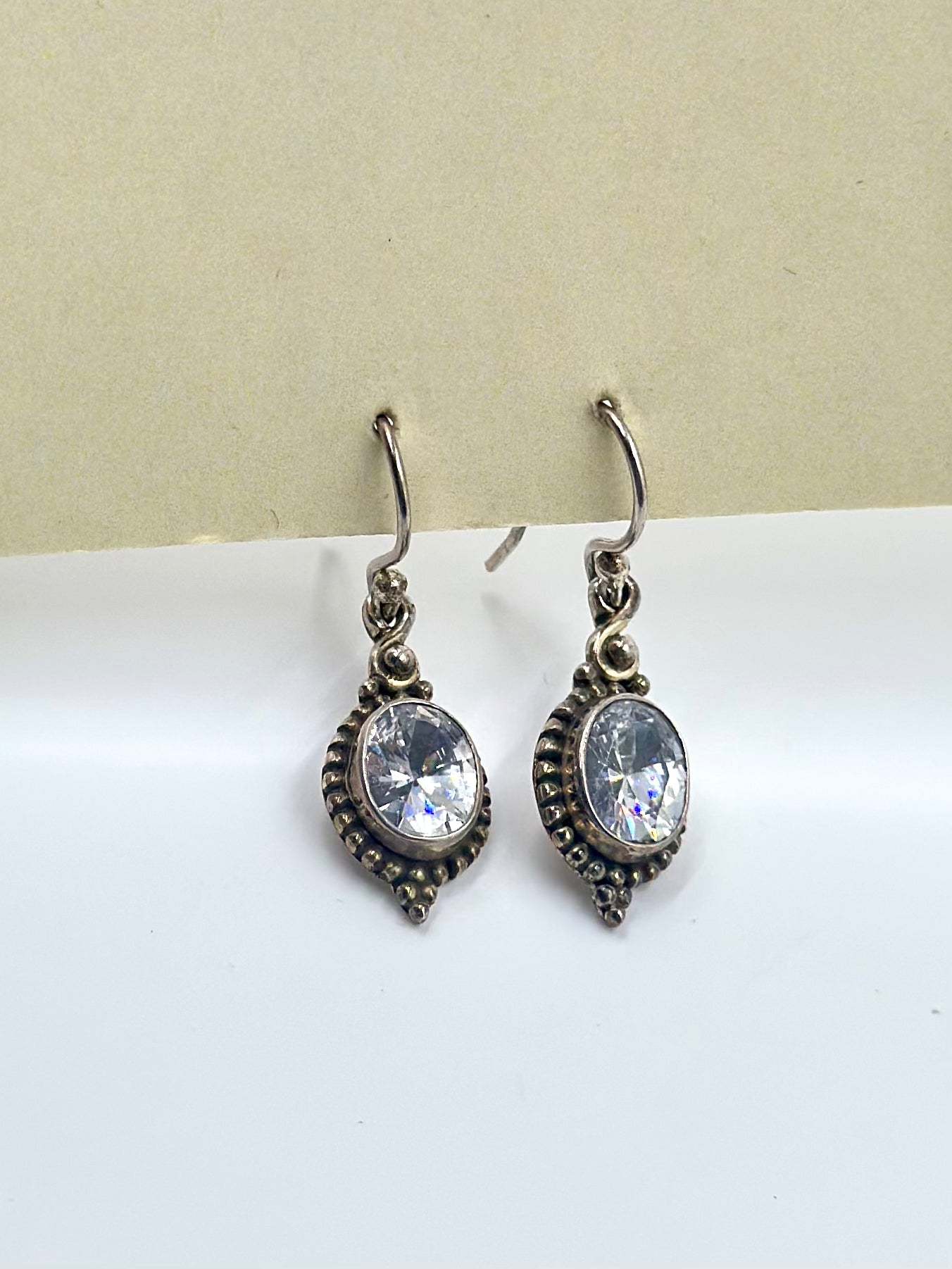 With an emerald centre piece and fine oxidised detailing around, sterling silver drop earrings